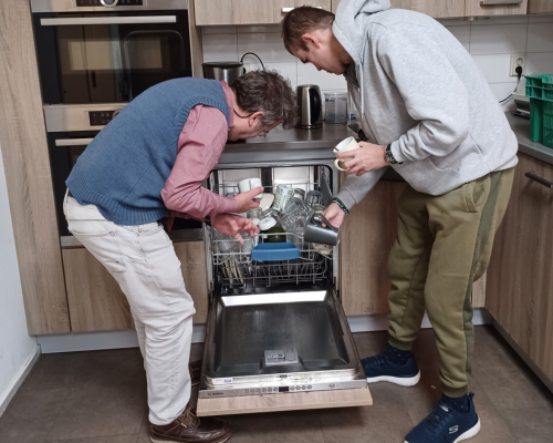 10.00 uur  Voordat we aan de slag gaan moet de vaatwasser nog ingeruimd en aangezet worden. Peter en Ward gaan aan het werk. Samen is de klus snel geklaard.